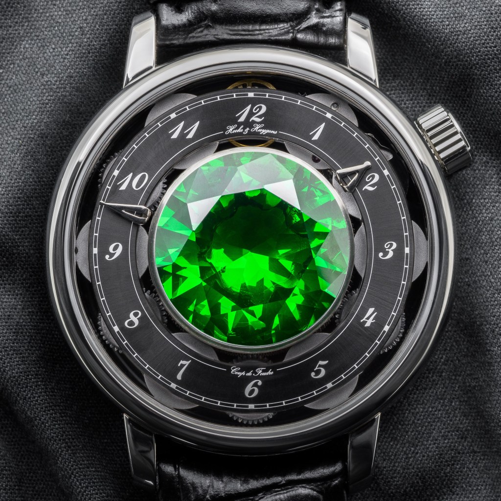 A photograph of the Hooke and Huygens watch with an oversized emerald.